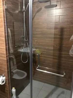 a shower with a glass door with a toilet at Best Value Q Condo Radiance29S near Airport, Casinos, Star City, MOA, PICC, Harbour Square, Dolomite Beach in Manila