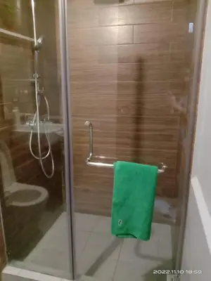 a bathroom with a green towel on a shower stall at Best Value Q Condo Radiance29S near Airport, Casinos, Star City, MOA, PICC, Harbour Square, Dolomite Beach in Manila