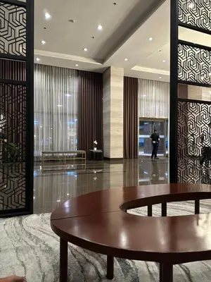 a lobby with a table and a person walking in a building at Best Value Q Condo Radiance29S near Airport, Casinos, Star City, MOA, PICC, Harbour Square, Dolomite Beach in Manila