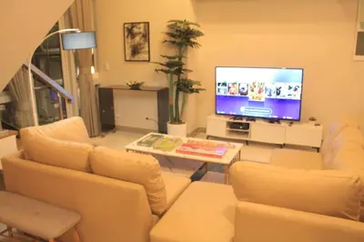 a living room with white furniture and a flat screen tv at A2J Luxury 3BR Suite Near Uptown Mall BGC Taguig in Manila