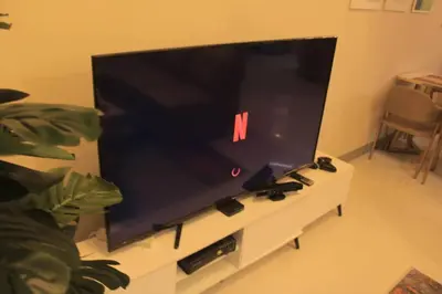 a large flat screen tv sitting on a white entertainment center at A2J Luxury 3BR Suite Near Uptown Mall BGC Taguig in Manila