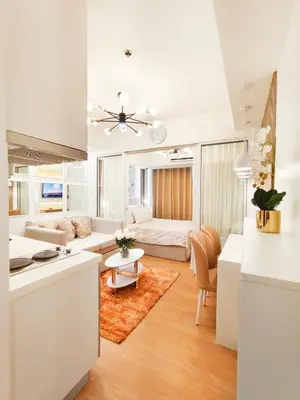 a kitchen and living room with a couch and a table at The Bahama Hammock - Azure PH in Manila