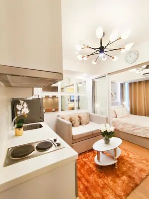 a kitchen and living room with a stove and a couch at The Bahama Hammock - Azure PH in Manila