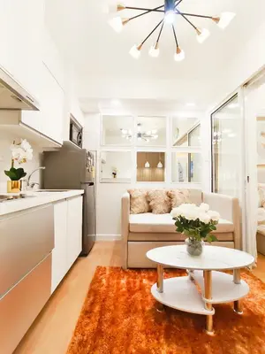 a kitchen and living room with a couch and a table at The Bahama Hammock - Azure PH in Manila