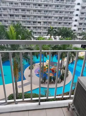 a view of the pool from the balcony of a resort at SHELL RESIDENCE c11 SHORWALK MALL OF ASIA & AIRPORT in Manila