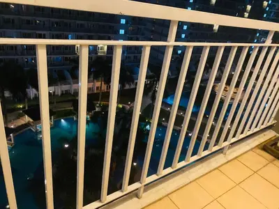 a balcony with a view of the city at night at SHELL RESIDENCE c11 SHORWALK MALL OF ASIA & AIRPORT in Manila