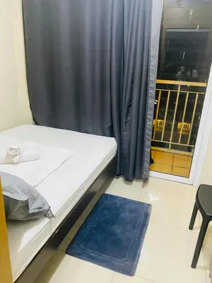 a bed in a room with a window and a mat at SHELL RESIDENCE C10 SHORWALK TO MALL OF ASIA NEAR AIRPORT in Manila