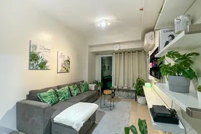 a living room with a couch and some plants at Family size Staycation in Makati with new year's firework balcony view in Manila