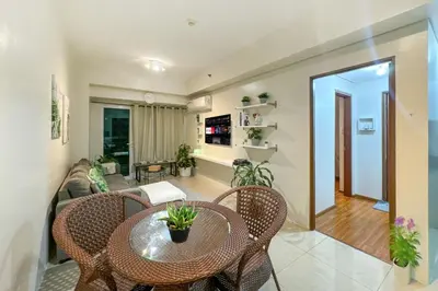 a living room with a table and chairs at Family size Staycation in Makati with new year's firework balcony view in Manila