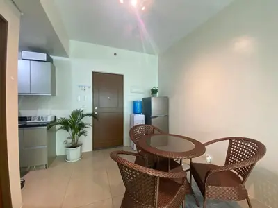 a kitchen with a table and chairs and a refrigerator at Family size Staycation in Makati with new year's firework balcony view in Manila