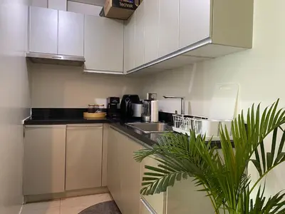 a kitchen with white cabinets and a potted plant at Family size Staycation in Makati with new year's firework balcony view in Manila