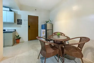 a kitchen with a table and chairs and a refrigerator at Family size Staycation in Makati with new year's firework balcony view in Manila