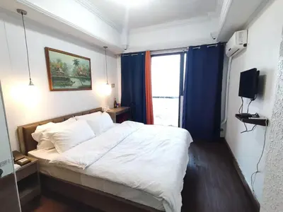 a bedroom with a large white bed with blue curtains at TemporaryHome -susan in Manila