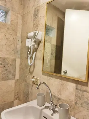 a bathroom with a sink and a hair dryer on the wall at TemporaryHome -susan in Manila
