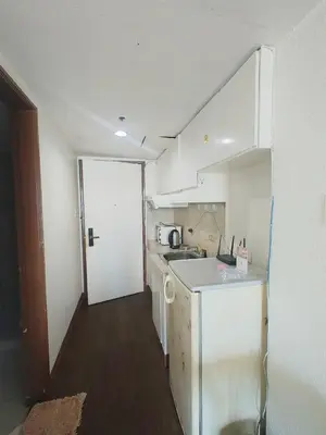 a small kitchen with white cabinets and a counter top at TemporaryHome -susan in Manila