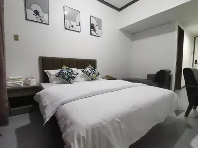a bedroom with a large white bed and a desk at TemporaryHome -susan in Manila