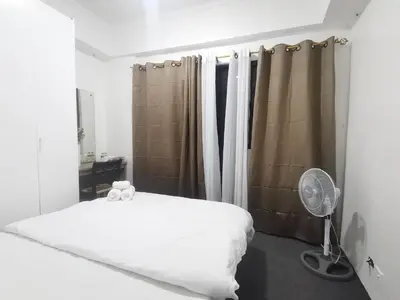 a bedroom with a white bed and a fan at Accommodation services in Manila