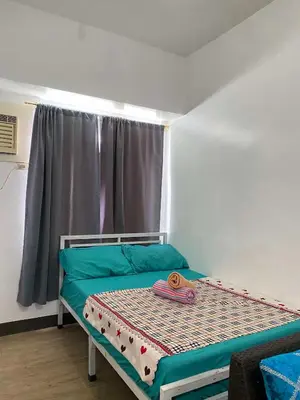 a small bed in a room with a window at staycation affordable in Manila