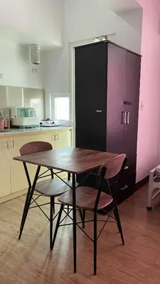 a kitchen with a table and two chairs and a refrigerator at staycation affordable in Manila