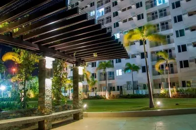 a large building with palm trees and a bench at staycation affordable in Manila