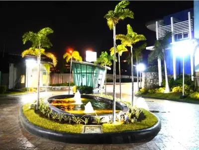 a fountain in a courtyard with palm trees at night at staycation affordable in Manila