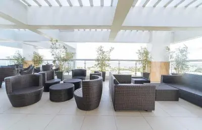 a lobby with wicker chairs and tables in a building at staycation affordable in Manila