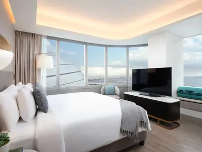 a bedroom with a large white bed and a large window at Lanson Place Mall of Asia Manila in Manila