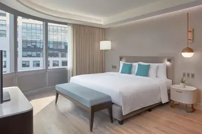 a bedroom with a large white bed with blue pillows at Lanson Place Mall of Asia Manila in Manila