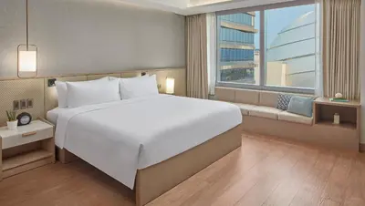 a large white bed in a room with a window at Lanson Place Mall of Asia Manila in Manila