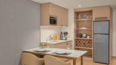 a kitchen with a table and chairs and a refrigerator at Lanson Place Mall of Asia Manila in Manila
