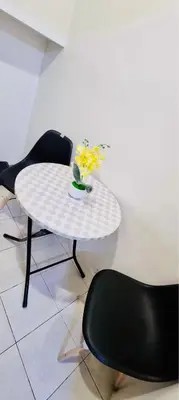 a white table with a vase of flowers on it at 2 BR staycation beside Enchanted Kingdom in Santa Rosa