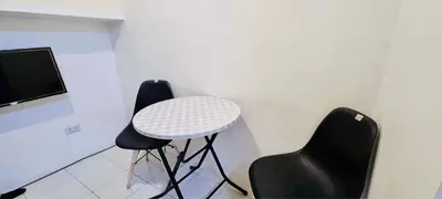 a room with two chairs and a table and a tv at 2 BR staycation beside Enchanted Kingdom in Santa Rosa