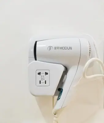 a hair dryer hanging on a wall at NomadsMNL Airport Hostel in Manila
