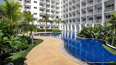 a swimming pool in front of a large building at Shore Residence Tower C2 in Manila