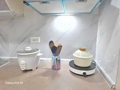 a kitchen counter with a coffee maker and utensils at Stylish 1BR with Wifi and Queen size bed in Grace Res in Manila