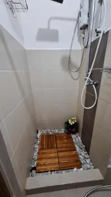 a shower with a wooden floor in a bathroom at Stylish 1BR with Wifi and Queen size bed in Grace Res in Manila