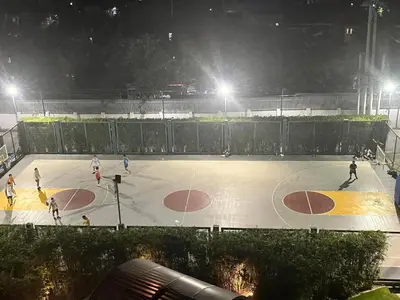 a group of people playingbasketball on a basketball court at night at Stylish 1BR with Wifi and Queen size bed in Grace Res in Manila