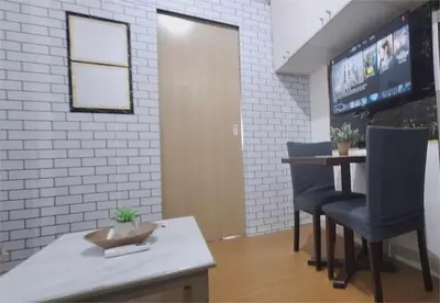 a bar with two blue chairs and a table at Stylish 1BR with Wifi and Queen size bed in Grace Res in Manila