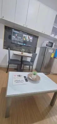 a table with two chairs and a tv in a room at Stylish 1BR with Wifi and Queen size bed in Grace Res in Manila