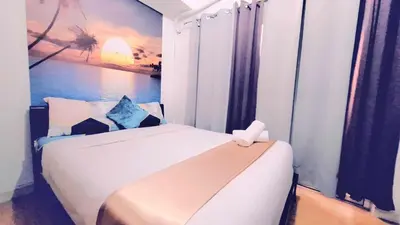 a bedroom with a bed with a painting on the wall at Stylish 1BR with Wifi and Queen size bed in Grace Res in Manila