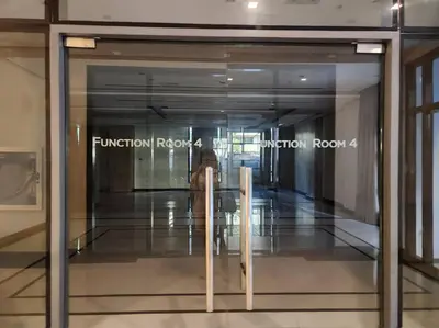 a glass door in a building with a person walking through it at Casa Antonio at Viceroy McKinley Hill in Manila