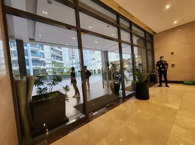 a police officer standing in a lobby with people in a building at Casa Antonio at Viceroy McKinley Hill in Manila