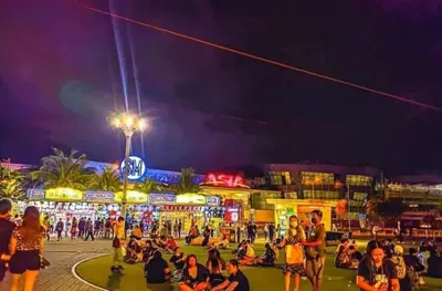 a crowd of people sitting on the street at night at SHORE RESIDENCE D9 Shortwalk Mall of Asia Near Airport in Manila