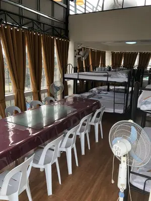a room with a table and chairs and bunk beds at THE MANSION: 18 PAX BUDGET NEAR AIRPORT TERMINAL PASAY in Manila