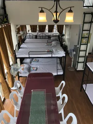 a room with two beds and a table and chairs at THE MANSION: 18 PAX BUDGET NEAR AIRPORT TERMINAL PASAY in Manila