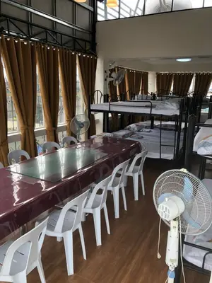 a room with a table and chairs and bunk beds at THE MANSION: 18 PAX BUDGET NEAR AIRPORT TERMINAL PASAY in Manila