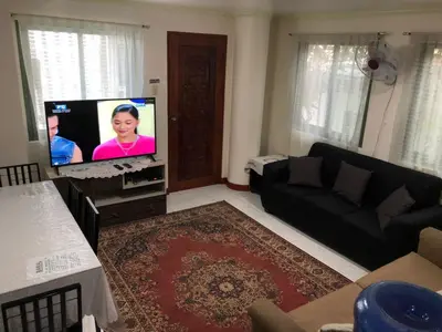 a living room with a couch and a flat screen tv at THE MANSION: FAMILY AND BARKADA BONDING PLACE IN PASAY NEAR AIRPORT in Manila