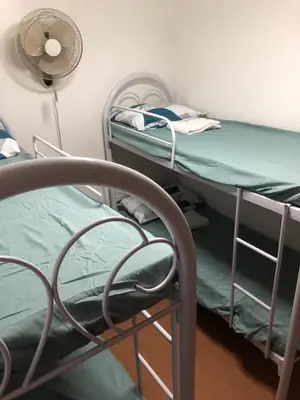 a room with two bunk beds and a fan at THE MANSION: FAMILY AND BARKADA BONDING PLACE IN PASAY NEAR AIRPORT in Manila
