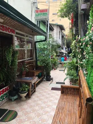 a store with benches and potted plants on a street at THE MANSION: FAMILY AND BARKADA BONDING PLACE IN PASAY NEAR AIRPORT in Manila