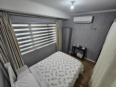 a small bedroom with a bed and a window at South of Market Private Residence in Manila